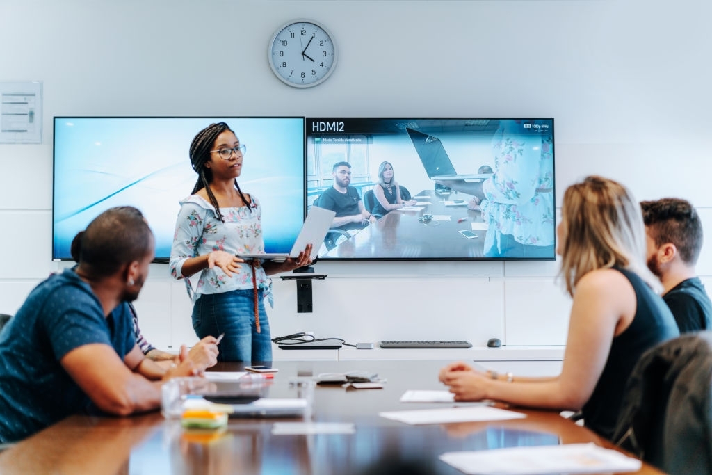 Brazilian colleagues discussing during video conference in meeting room