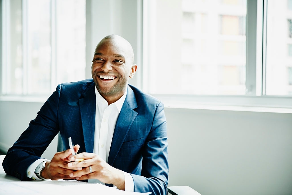 Smiling businessman in discussion at workstation in office
